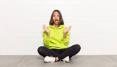 İspanyol kadın beklenmedik bir sürprizden dolayı şaşkın, heyecanlı, gülen, şaşkın ve mutlu hissediyor.