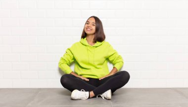 İspanyol kadın neşeli, mutlu, kendinden emin ve rahat bir ifadeyle gülümsüyor.