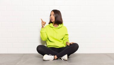 İspanyol kadın şaşkın ve şaşırmış hissediyor, şaşırmış ve hayranlıkla yukarı bakıyor, şaşkın, açık ağızlı bir bakışla