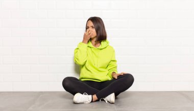 İspanyol kadın iğreniyor, kötü ve nahoş bir koku duymamak için burnunu tutuyor.