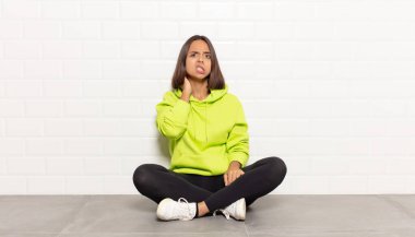 İspanyol kadın kendini stresli, hayal kırıklığına uğramış ve yorgun hissediyor. Endişeli ve sorunlu bir bakışla boynunu okşuyor.