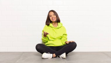 İspanyol kadın gülümsüyor, mutlu görünüyor, kendinden emin ve arkadaş canlısı, bir anlaşma yapmak için el sıkışma teklif ediyor, işbirliği yapıyor.