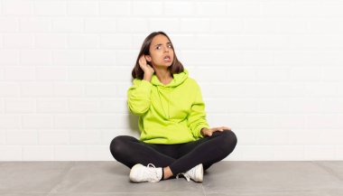 İspanyol kadın ciddi ve meraklı görünüyor, dinliyor, gizli bir konuşma ya da dedikodu duymaya çalışıyor, gizlice dinliyor.