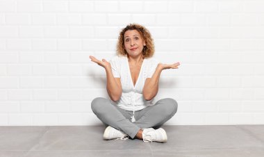 Orta yaşlı kadın şaşkın ve şaşkın hissediyor, şüpheci, farklı seçenekleri tartıyor veya komik bir ifadeyle seçiyor.