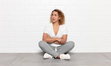 Orta yaşlı bir kadın şüpheye düşüyor ya da düşünüyor, dudağını ısırıyor ve kendini güvensiz ve gergin hissediyor, kenarda yer arıyor.