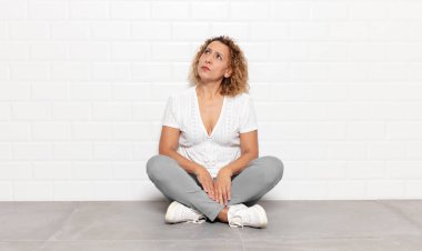 Endişeli, kafası karışık, budala bir ifadeyle orta yaşlı kadın, kopya alanı arıyor, şüphe ediyor.