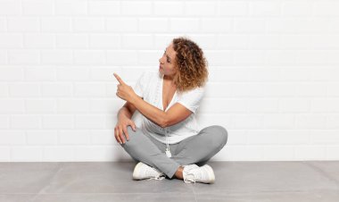 Orta yaşlı kadın dikey görünüm ve kopyalama alanı üzerinde duran ve nesneyi işaret eden