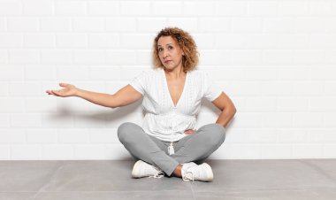 Orta yaşlı bir kadın kendini mutlu ve neşeli hissediyor, gülümsüyor ve seni hoş karşılıyor, dostça bir jestle içeri davet ediyor.