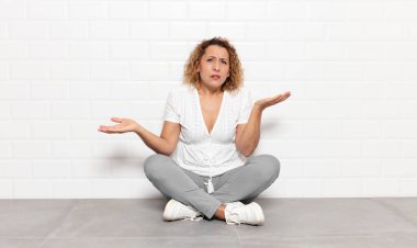 Orta yaşlı kadın şaşkın, kafası karışmış ve stresli görünüyor, farklı seçenekler arasında merak ediyor, kararsız hissediyor.