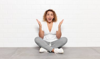 Orta yaşlı bir kadın mutlu, heyecanlı, şaşırmış ya da şaşırmış hissediyor, gülümsüyor ve hayret verici bir şeye şaşırıyor.