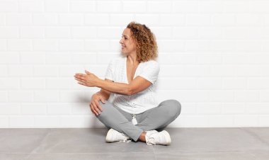 Orta yaşlı bir kadın gülümsüyor, sizi selamlıyor ve başarılı bir anlaşma için el sıkışmayı teklif ediyor.