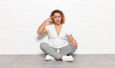 Orta yaşlı bir kadın kafası karışık ve şaşkın hissediyor. Deli, deli ya da aklını kaçırmış olduğunu gösteriyor.