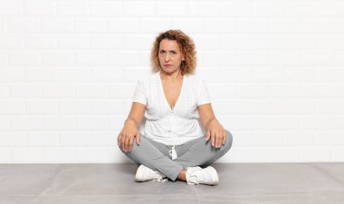 Orta yaşlı bir kadın üzgün, üzgün ya da kızgın ve olumsuz bir tavır takınıyor, anlaşmazlık içinde kaşlarını çatıyor.