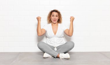 Orta yaşlı bir kadın inanılmaz bir başarıyı kutluyor. Kazanan gibi, heyecanlı ve mutlu görünüyor.!