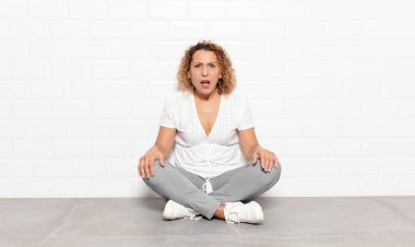 Orta yaşlı bir kadın şok olmuş, kızgın, sinirli ya da hayal kırıklığına uğramış, ağzı açık ve öfkeli görünüyor.