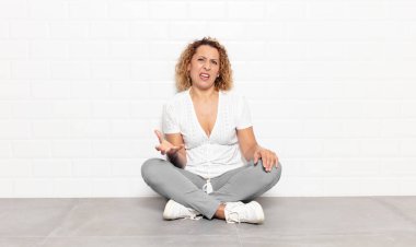 Orta yaşlı bir kadın sinirli, sinirli ve sinirli görünüyor. Senin neyin var? 