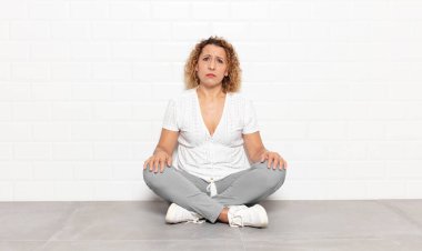 Orta yaşlı bir kadın üzgün ve mızmızlanıyor, mutsuz bir bakışla, negatif ve hayal kırıklığına uğramış bir tavırla ağlıyor.