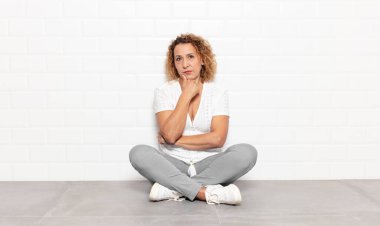 Orta yaşlı kadın ciddi görünüyor, kafası karışık, kararsız ve düşünceli, seçenekler ve seçenekler arasında şüpheci.