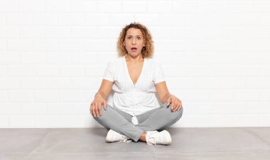 Orta yaşlı kadın korkmuş ve şok olmuş hissediyor, ağzı açık şaşkınlık içinde.