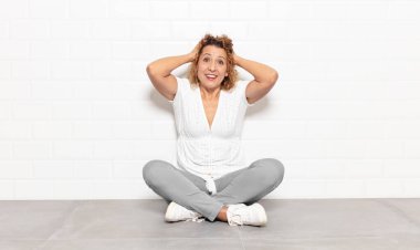 Orta yaşlı bir kadın el ele tutuşuyor, ağzı açık, son derece şanslı, şaşırmış, heyecanlı ve mutlu.