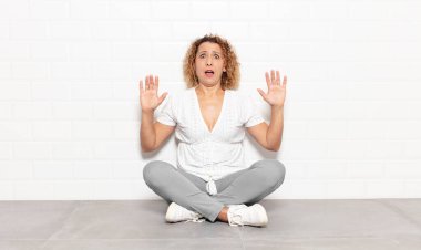 Orta yaşlı bir kadın sersemlemiş ve korkmuş hissediyor. Korkutucu bir şeyden korkuyor. Elleri açık ve uzak durun diyor.