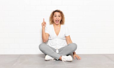 Bir fikri fark ettikten sonra mutlu ve heyecanlı bir dahi gibi hisseden orta yaşlı bir kadın, neşeli bir şekilde parmağını kaldırıyor, eureka!