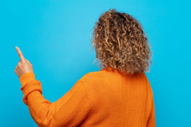 Orta yaşlı kadın dikey görünüm ve kopyalama alanı üzerinde duran ve nesneyi işaret eden