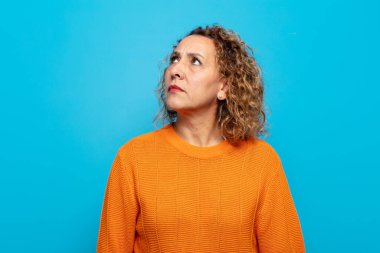 Endişeli, kafası karışık, budala bir ifadeyle orta yaşlı kadın, kopya alanı arıyor, şüphe ediyor.