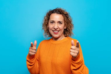 Orta yaşlı bir kadın kendini mutlu, havalı, tatmin olmuş, rahat ve başarılı hissediyor, kameraya bakıyor, seni seçiyor.