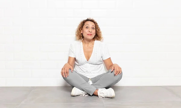 stock image middle age woman with a goofy, crazy, surprised expression, puffing cheeks, feeling stuffed, fat and full of food