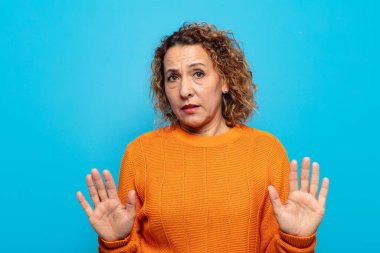 Orta yaşlı bir kadın gergin, endişeli ve endişeli görünüyor. Benim hatam olmadığını söylüyor. Yoksa ben yapmadım. 