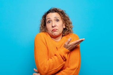 Orta yaşlı bir kadın kafası karışık ve bilgisiz, şüpheli bir açıklama ya da düşünceyi merak ediyor.