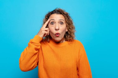 Orta yaşlı kadın şaşırmış, ağzı açık, şok olmuş, yeni bir düşünce, fikir ya da konsept keşfediyor.