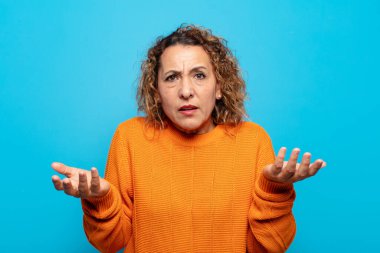 Orta yaşlı bir kadın bilgisiz ve kafası karışık, hangi seçeneği seçeceğinden emin değil, merak ediyor.