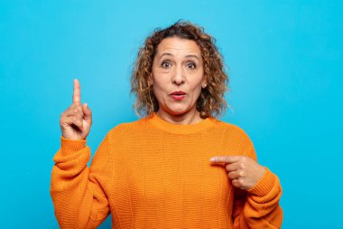 Orta yaşlı bir kadın gururlu ve şaşırmış, kendine güvenen, kendini bir numara gibi hisseden.