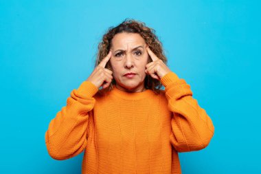 Orta yaşlı kadın odaklanmış ve bir fikir üzerinde kafa yoruyor, bir soruna ya da soruna bir çözüm hayal ediyor.