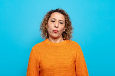 Orta yaşlı bir kadın aptal ve komik görünüyor. Şaşı bakışlı, şakacı ve şakacı.