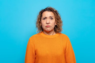 Orta yaşlı bir kadın üzgün ve stresli, kötü bir sürpriz yüzünden üzgün, olumsuz, endişeli bir bakışla