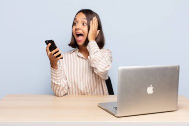 Hispanik kadın mutlu, heyecanlı ve şaşırmış hissediyor, iki eli yüzü yana bakıyor