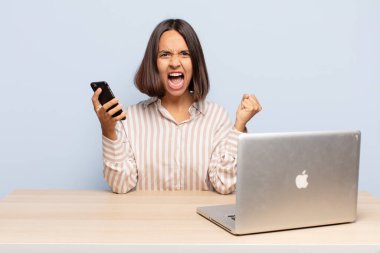 Öfkeli bir ifadeyle saldırganca bağıran İspanyol kadın mı yoksa başarıyı kutlayan yumruklarla mı?