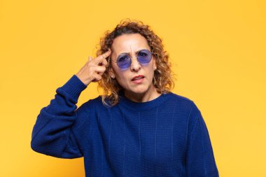 İspanyol orta yaşlı kadın şaşkın ve şaşkın hissediyor. Deli, deli ya da aklını kaçırmış olduğunu gösteriyor.