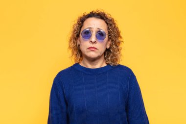 İspanyol orta yaşlı bir kadın üzgün ve mızmız, mutsuz bir bakışla, olumsuz ve hayal kırıklığına uğramış bir tavırla ağlıyor.