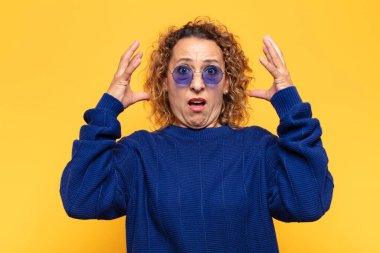 İspanyol orta yaşlı kadın elleri havada bağırıyor. Öfkeli, sinirli, stresli ve üzgün.