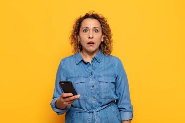 İspanyol orta yaşlı kadın şok olmuş ya da şaşırmış görünüyor, ağzı açık bir şekilde 