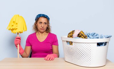 Hispanik orta yaşlı kadın üzgün, üzgün ya da kızgın hissediyor ve olumsuz bir tutumla yan yana bakıyor, anlaşmazlık içinde kaşlarını çatıyor