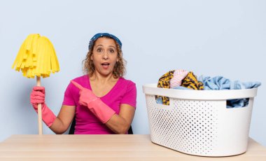 İspanyol orta yaşlı kadın heyecanlı ve şaşırmış görünüyor. Yana ve yukarıya bakıp boşluğu kopyalıyor.