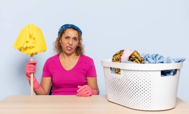 İspanyol orta yaşlı kadın tiksinmiş ve rahatsız olmuş hissediyor. Dilini dışarı çıkarıyor. İğrenç ve iğrenç bir şeyden hoşlanmıyor.