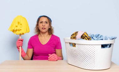 hispanic middle age woman feeling puzzled and confused, with a dumb, stunned expression looking at something unexpected