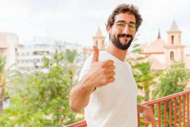 Genç sakallı adam evde dinleniyor.