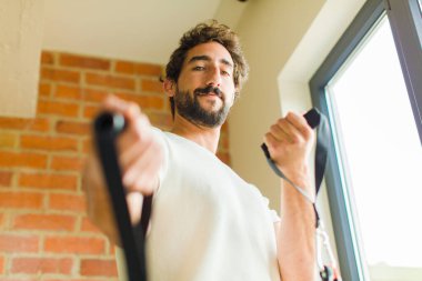 Genç sakallı adam evde egzersiz yapıyor.